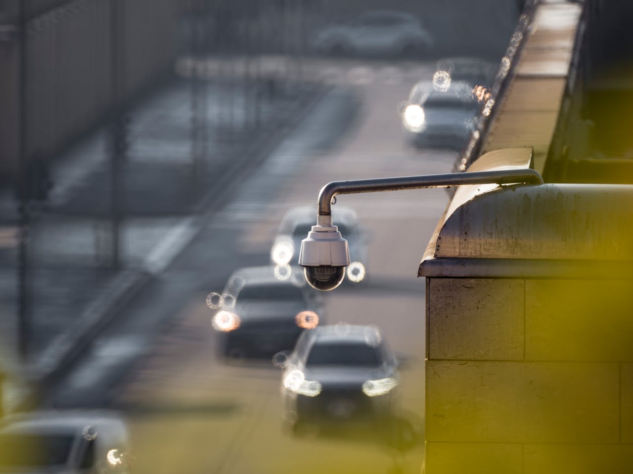 services-02 CCTV camera monitoring city traffic on a busy road with blurred vehicles in the background.